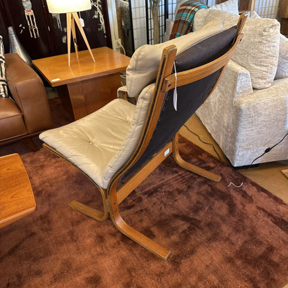 Wooden chair with beige cushion in a room with furniture and decor.