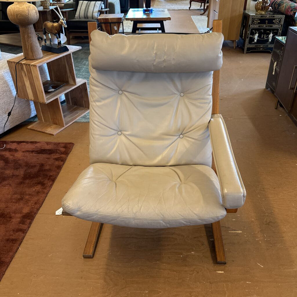White cushioned chair in a room with furniture and decor.
