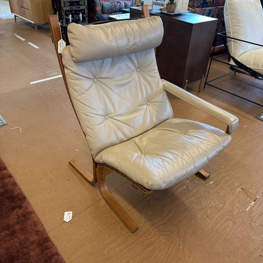 Beige leather armchair with wooden frame on a brown floor