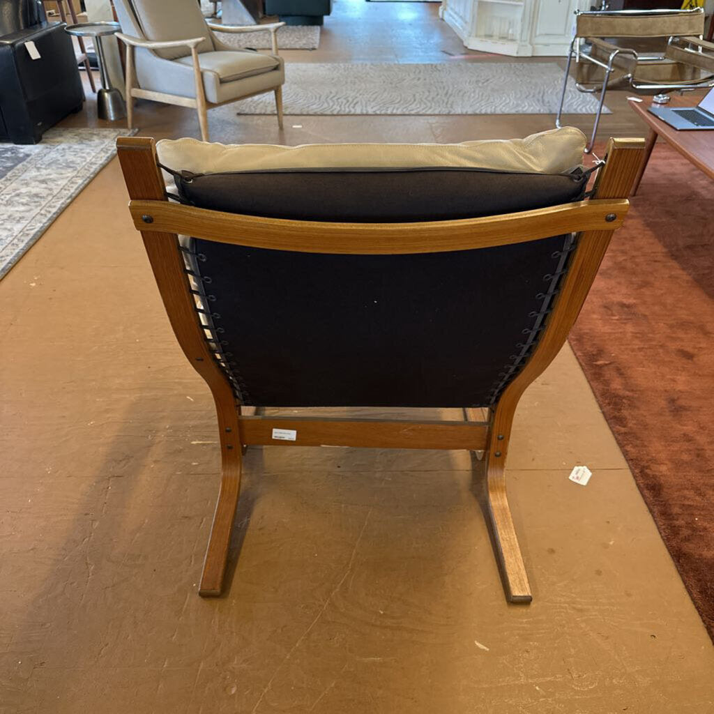 Chair with black seat and wooden frame on a brown floor
