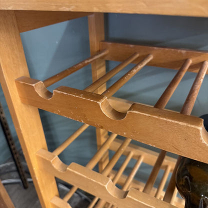 Wooden wine rack with bottles against a blue wall