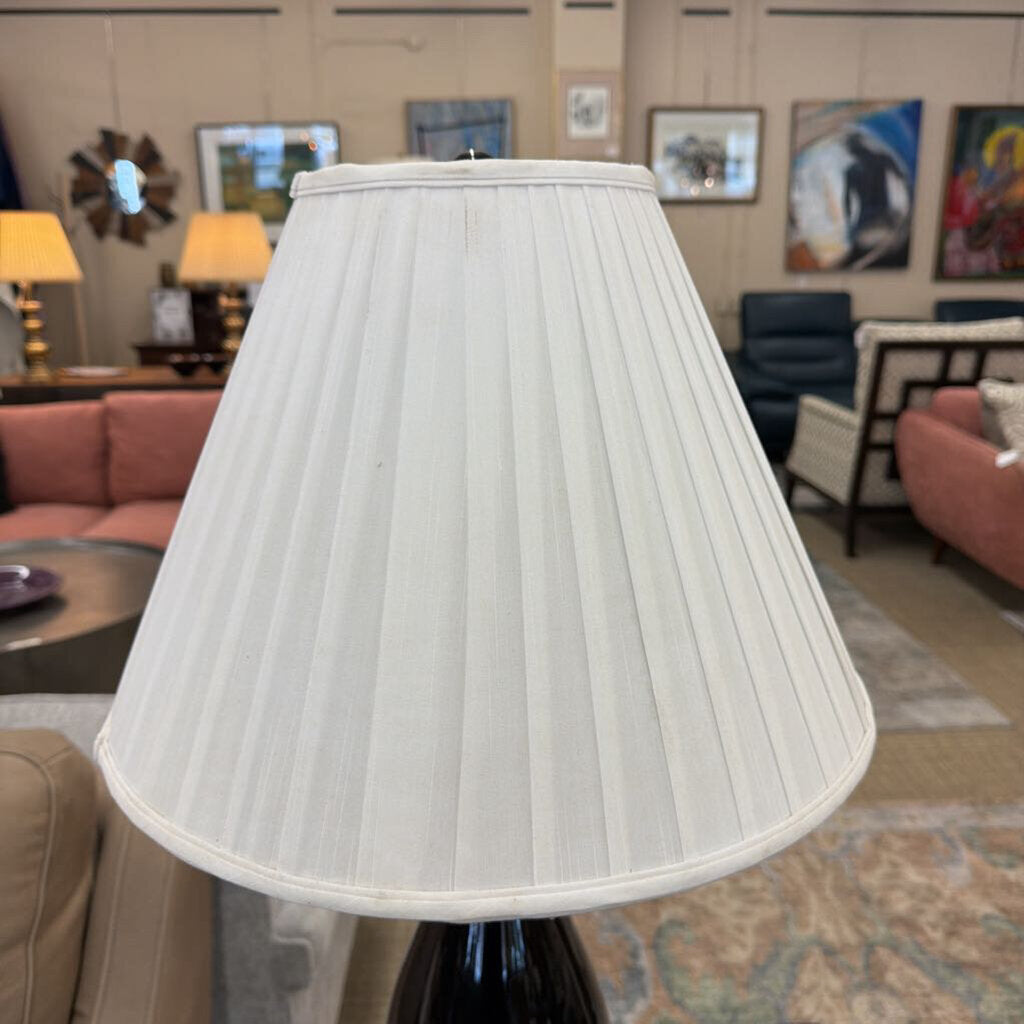 White pleated lampshade in a room with furniture and decor
