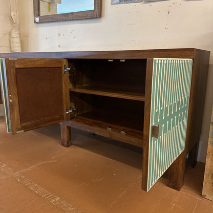 Wooden cabinet with one door open, revealing shelves inside, on a brown floor.