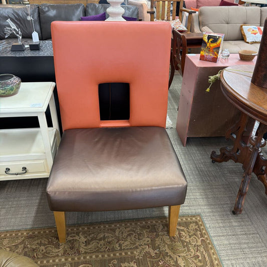Chair with orange backrest and brown seat in a furniture store setting