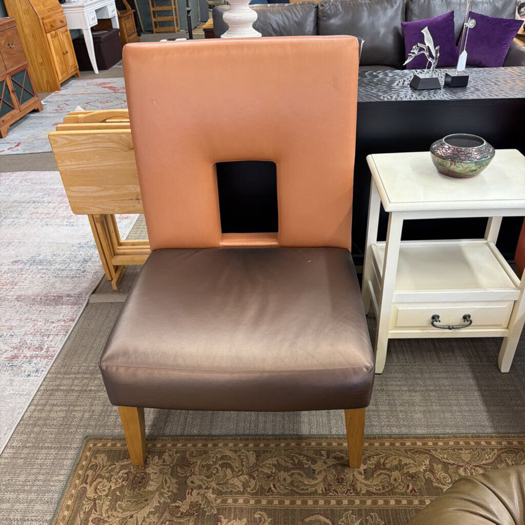 Chair with brown seat and backrest in a room setting with furniture and decor.