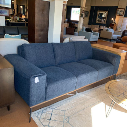 Blue sofa in a living room setting with other furniture and decor.