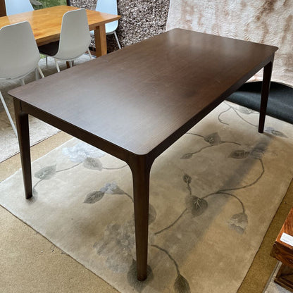 a walnut wood dining table in a showoom