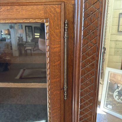 Wooden wardrobe with decorative patterns and a mirror on one side.