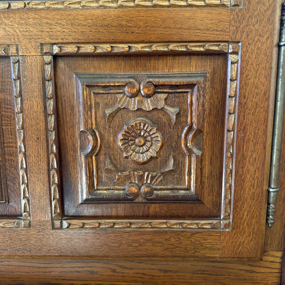 Close-up of a wooden panel with intricate carvings on a door.