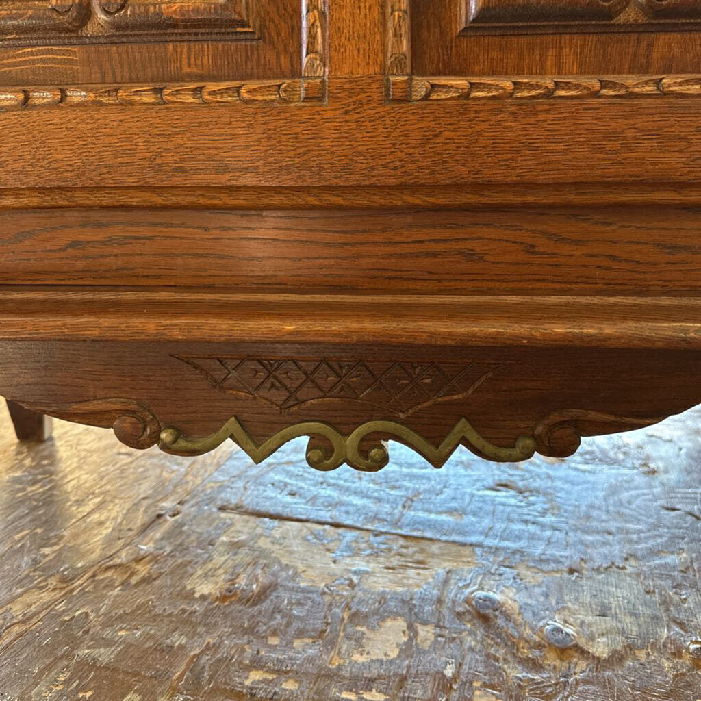 Close-up of a wooden surface with intricate carvings on a stone floor.
