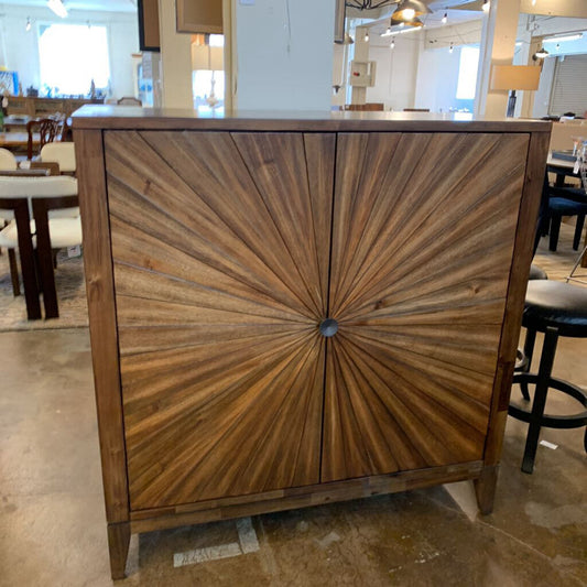 Wooden cabinet with sunburst design in a showroom setting