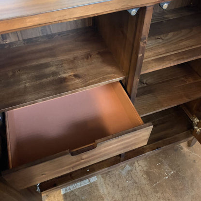 Wooden dresser with a drawer open, showing a worn surface.