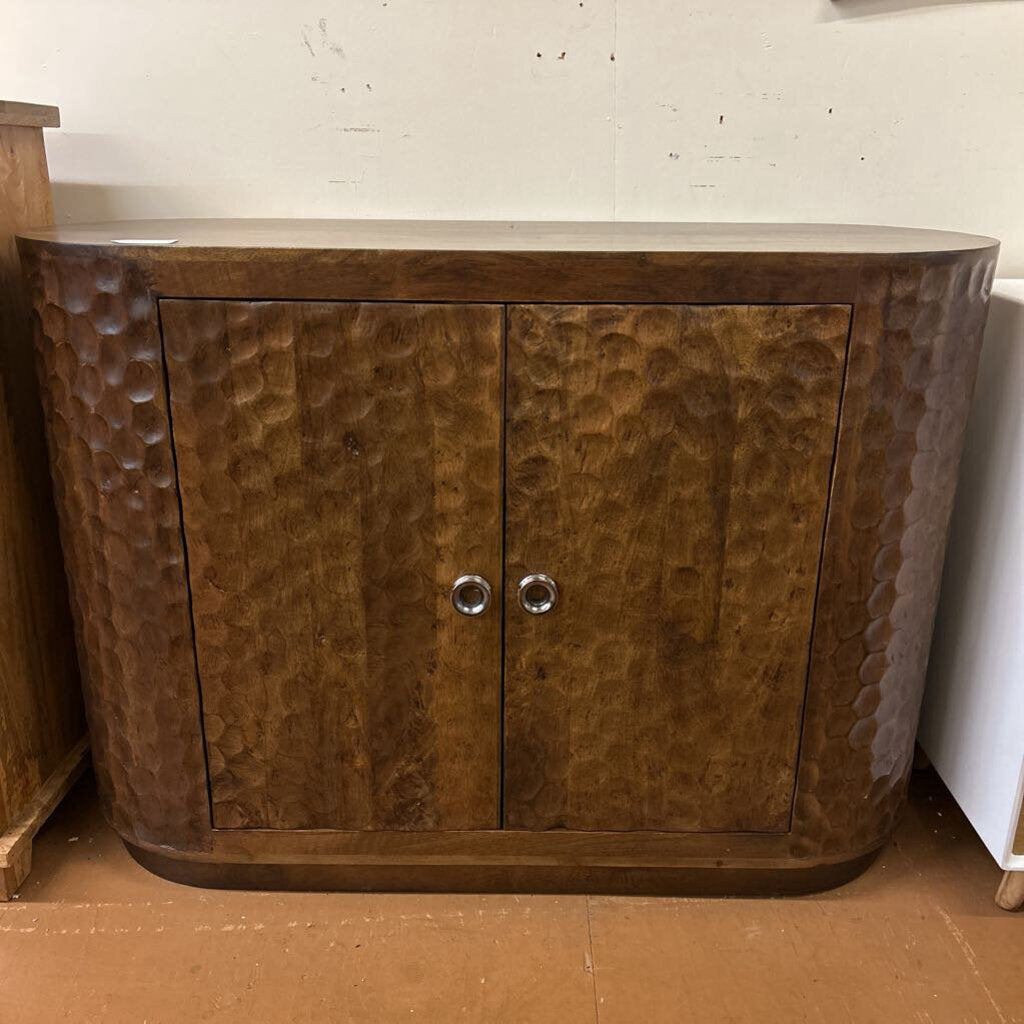 Wooden cabinet with textured surface and two doors on a plain background