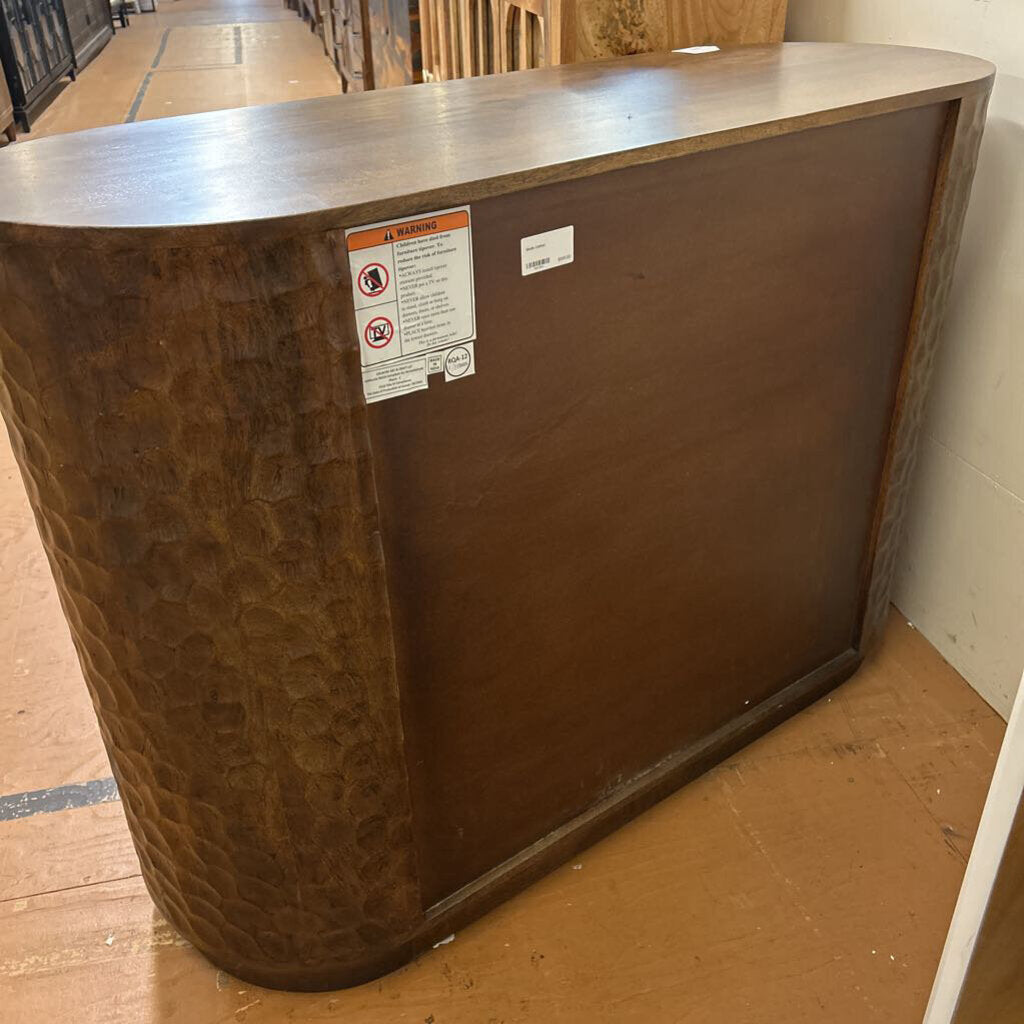 Brown furniture piece with warning labels on a wooden floor