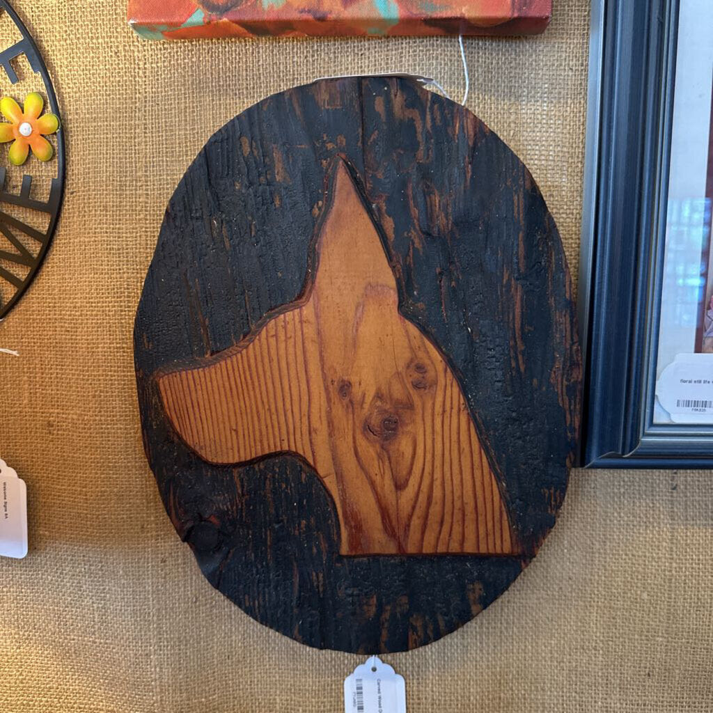 Wooden star-shaped cutting board on a textured surface with a tag.