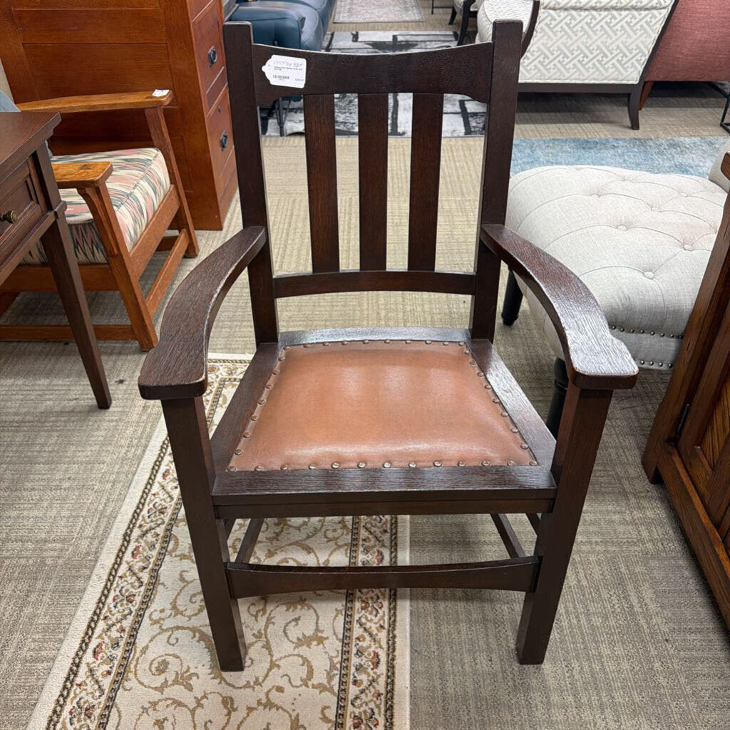 Wooden chair with a brown leather seat in a furniture store setting