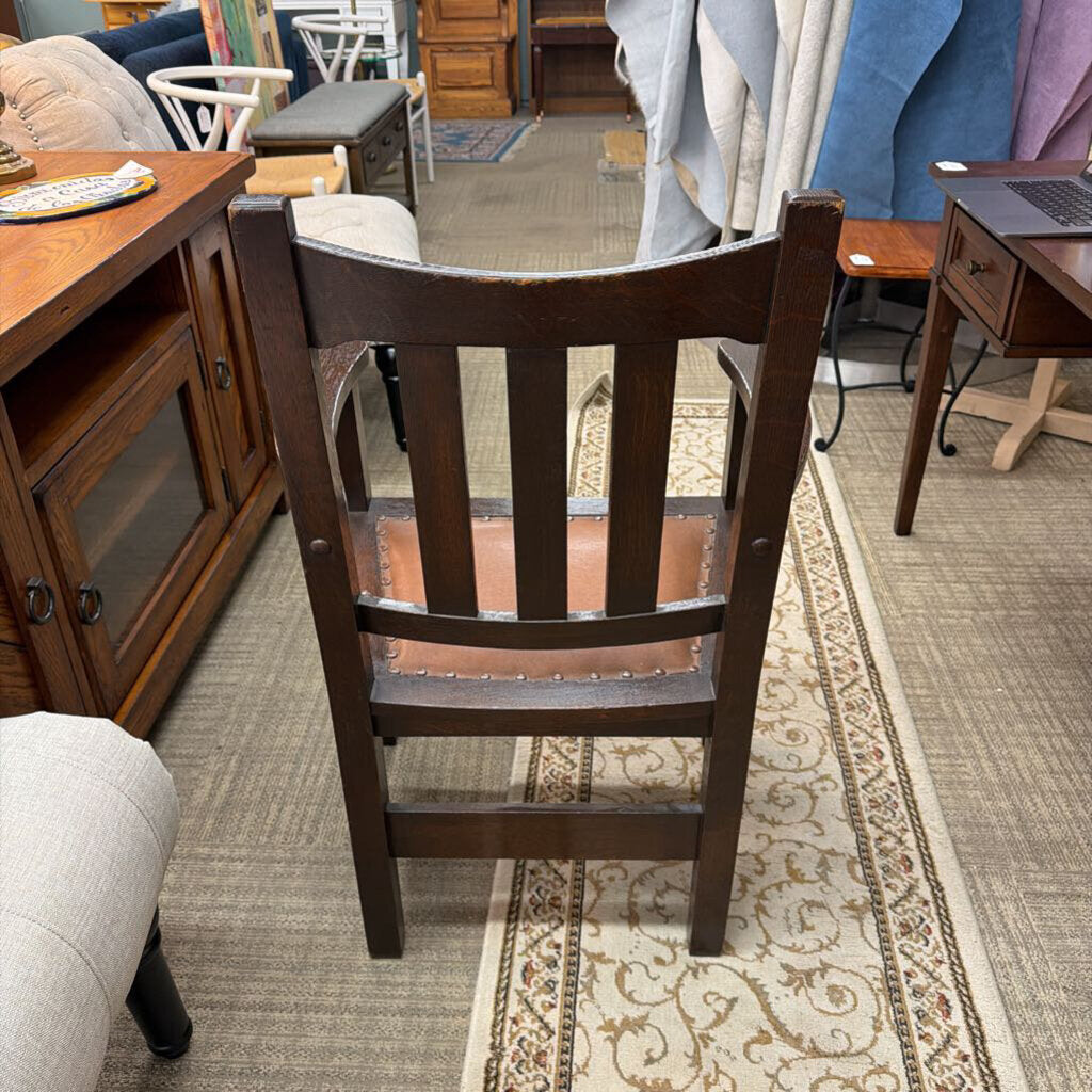 Wooden chair in a furniture store setting with various items in the background