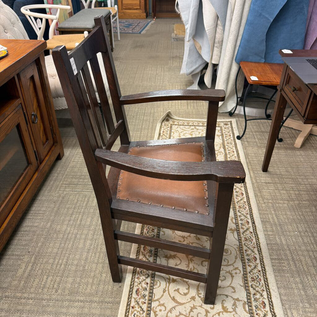 Wooden chair with brown leather seat in a furniture store setting