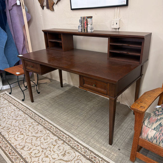 Wooden desk in a room with a rug and chair