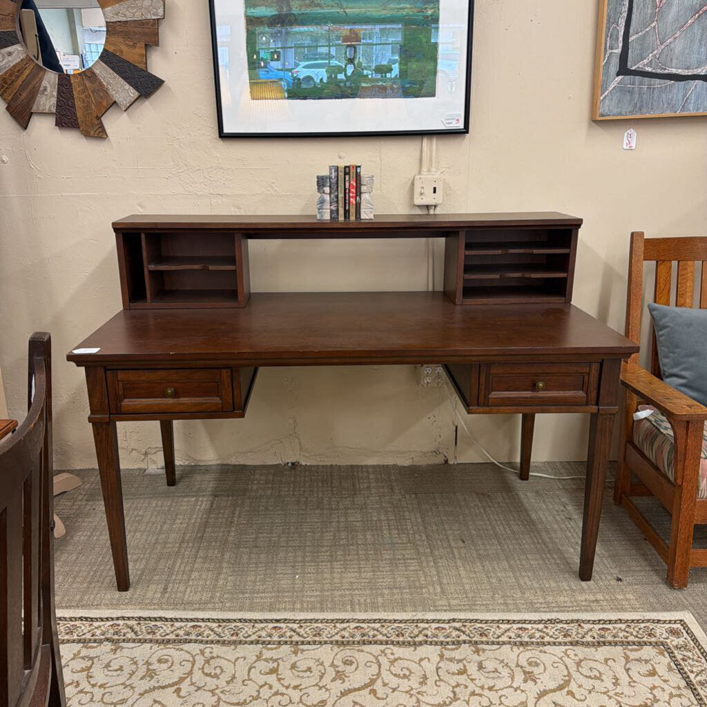 Wooden desk in a room with a chair and wall art