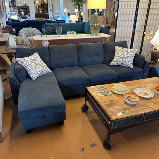 Blue sectional sofa with decorative pillows in a showroom setting