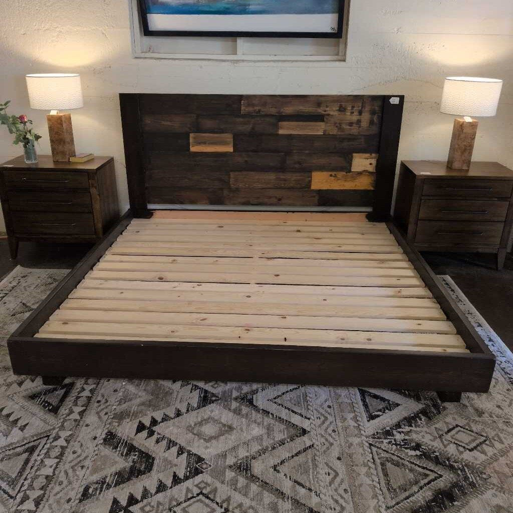 Wooden bed with dark wooden headboard and footboard in a room with lamps and decor.