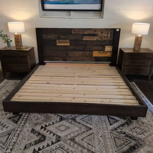 Wooden bed with dark wooden headboard and footboard in a room with lamps and decor.