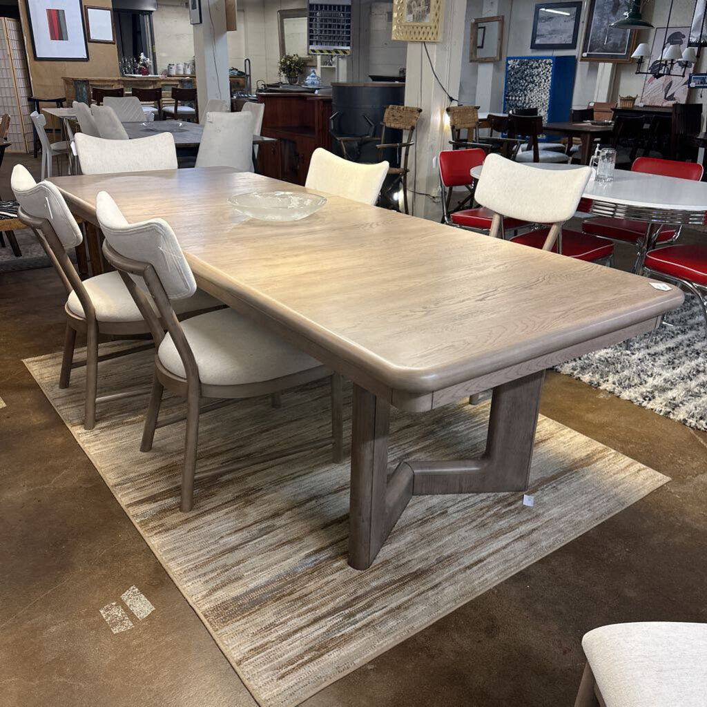 Wooden dining table with chairs in a showroom setting