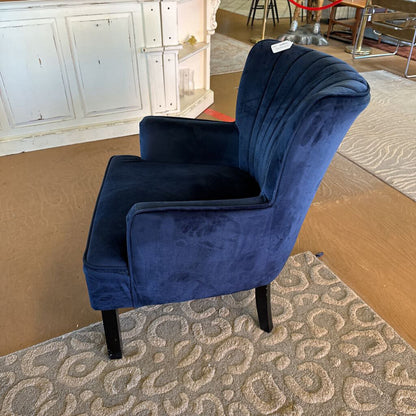 Blue armchair on a patterned rug with a neutral background