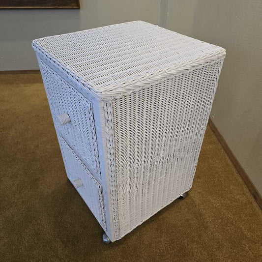 White wicker laundry basket with a blue liner on a brown carpeted floor.