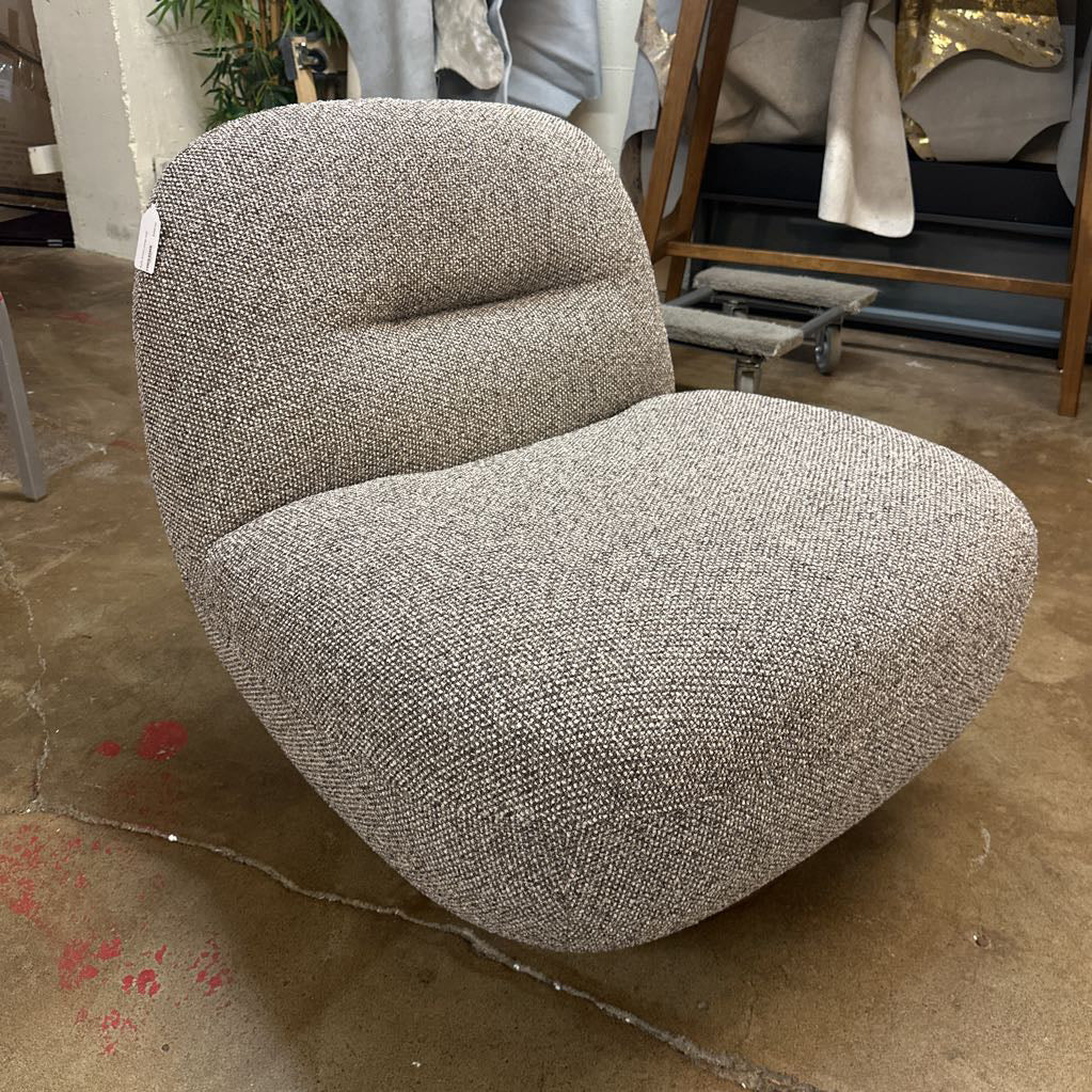Gray textured chair in a store setting with other furniture items.