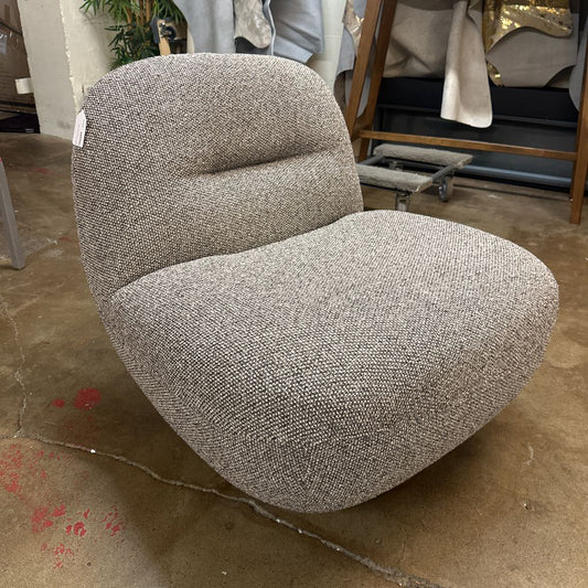 Gray textured chair in a store setting with other furniture items.