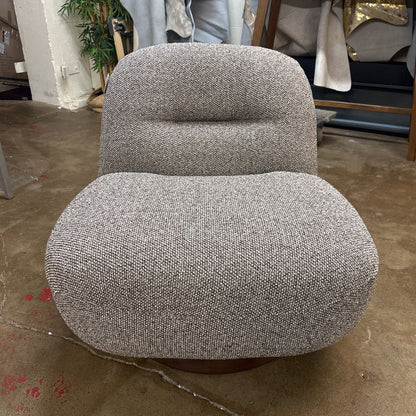 Gray textured armchair on a concrete floor with a blurred background