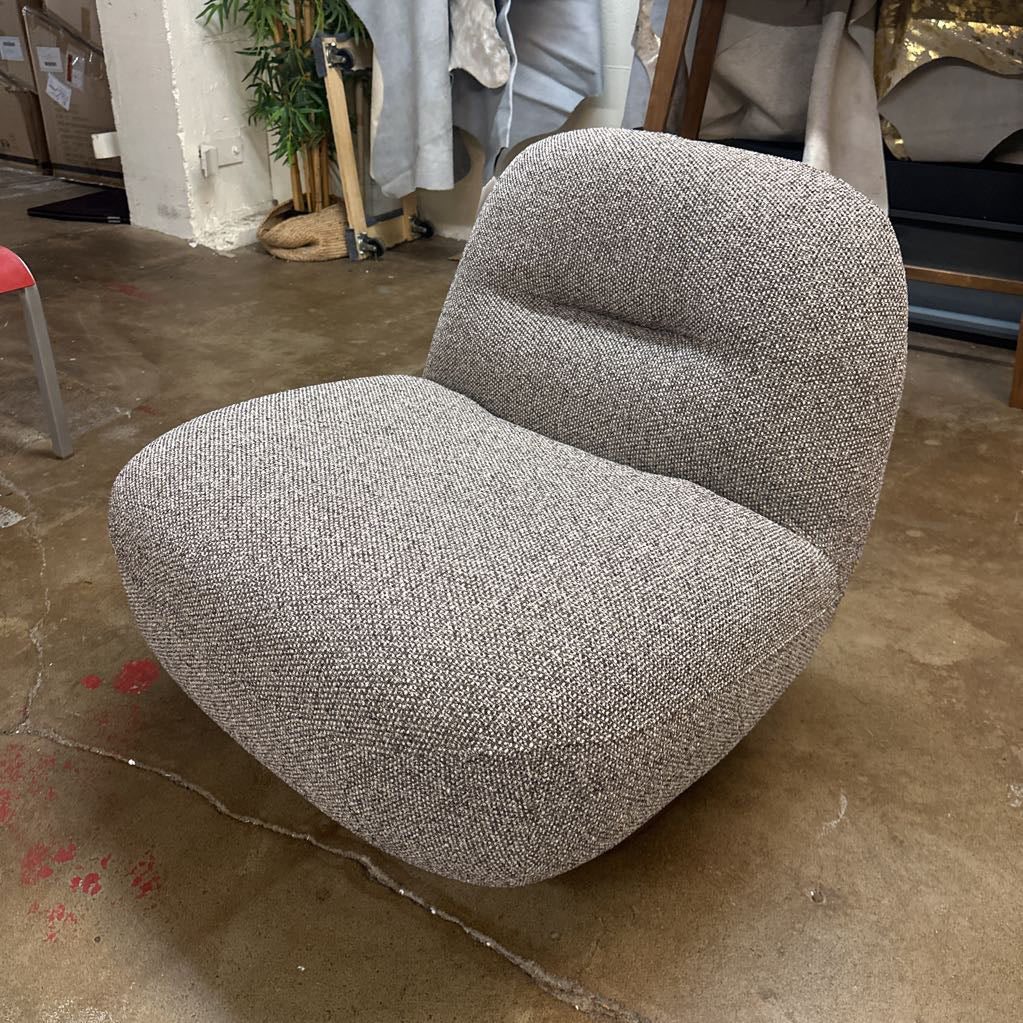 Gray textured chair on a concrete floor with a blurred background
