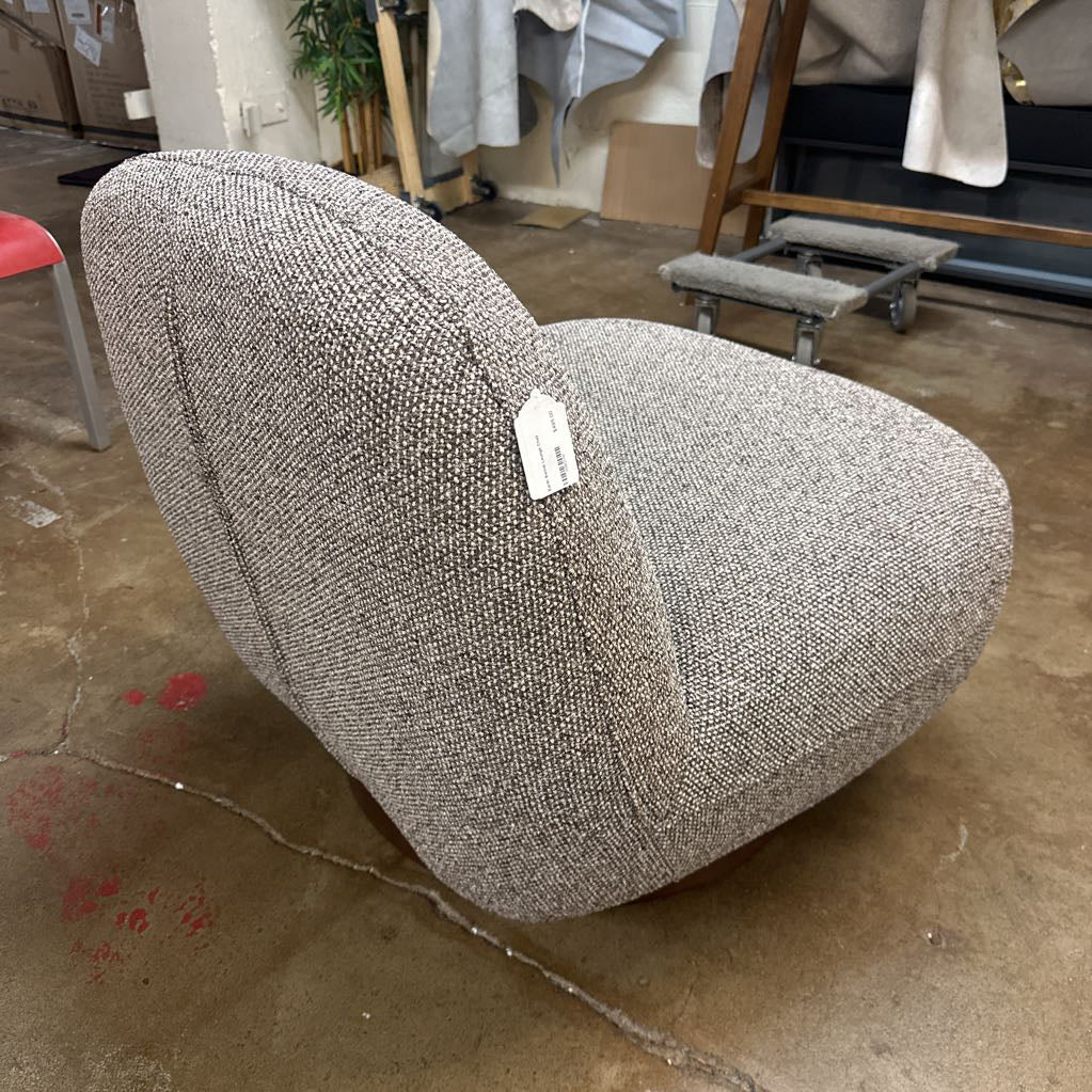 Gray textured armchair with a tag on a concrete floor in an indoor setting