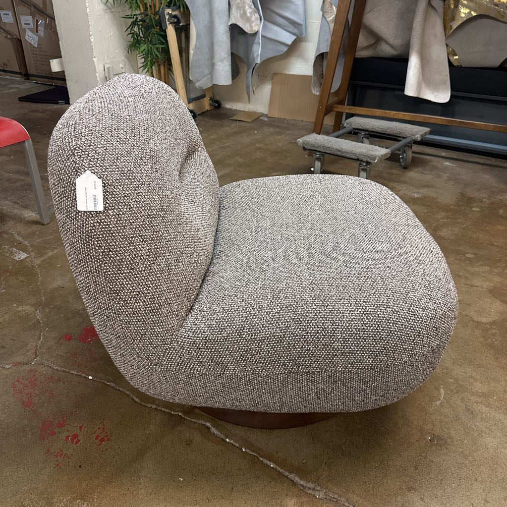 Gray textured chair with a tag on a brown floor in an indoor setting
