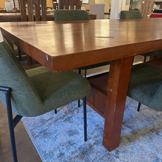Wooden dining table with green chairs in a room setting