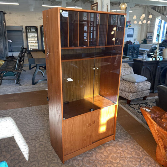 Wooden bookshelf with glass doors in a room setting