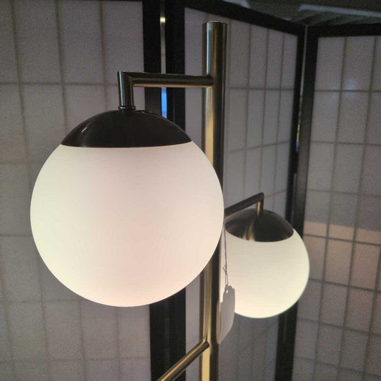 Spherical wall light fixture with black top and white bottom in a tiled room.