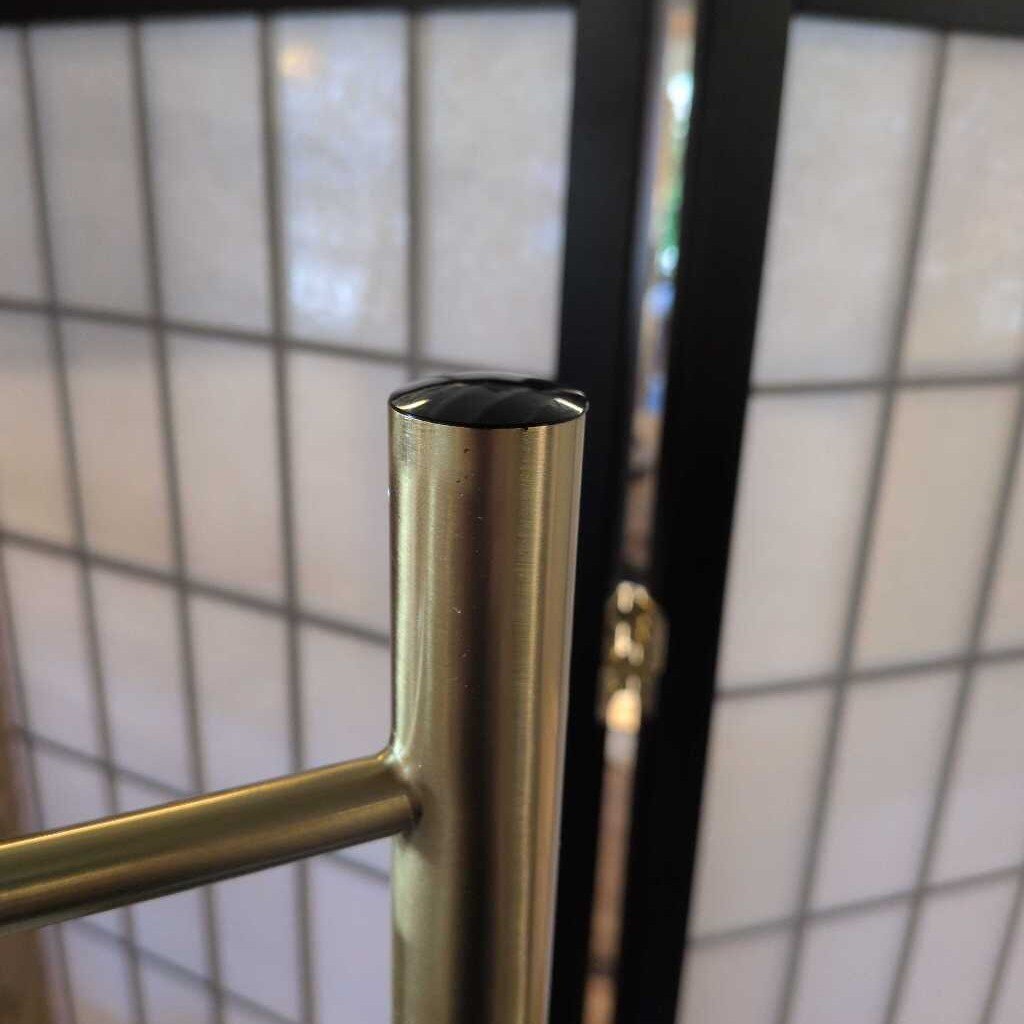 Close-up of a metallic door handle on a glass door with a grid pattern.