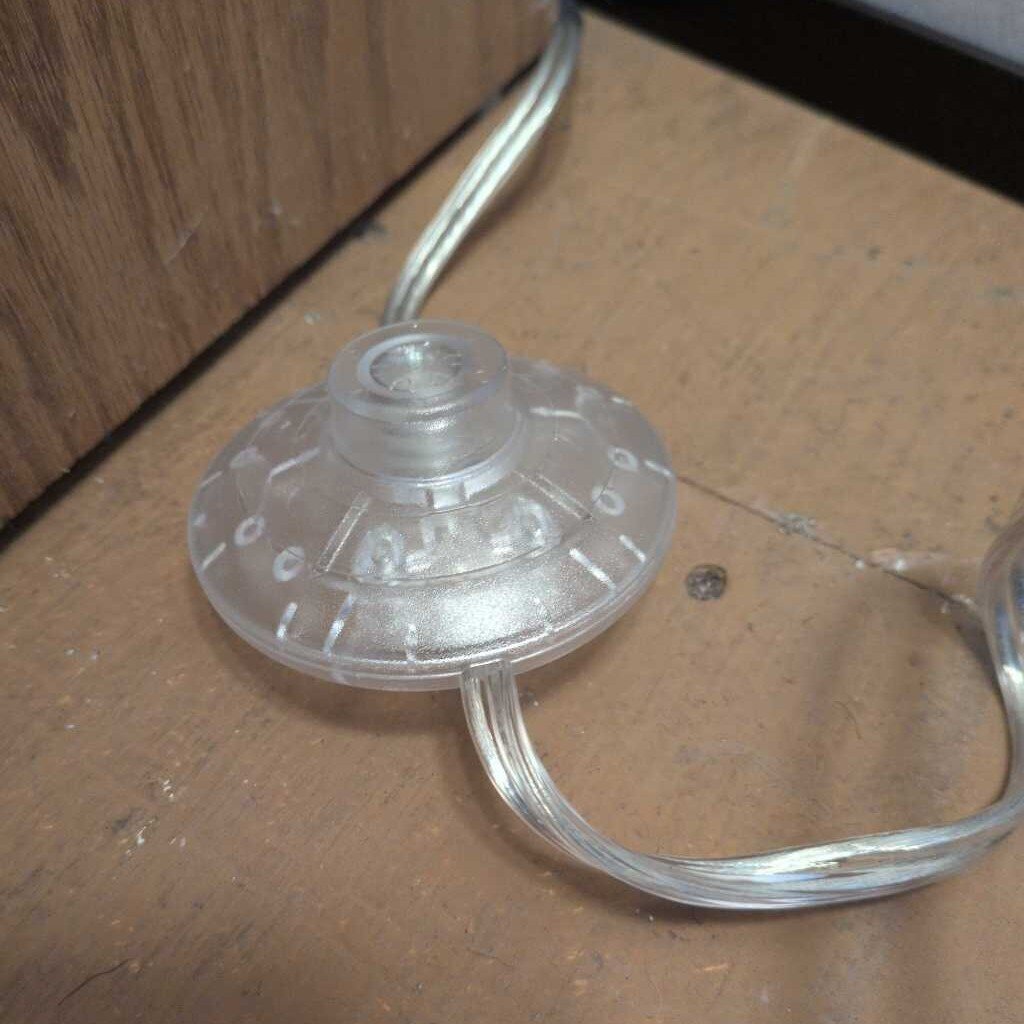 Clear plastic suction cup with a wire on a wooden surface