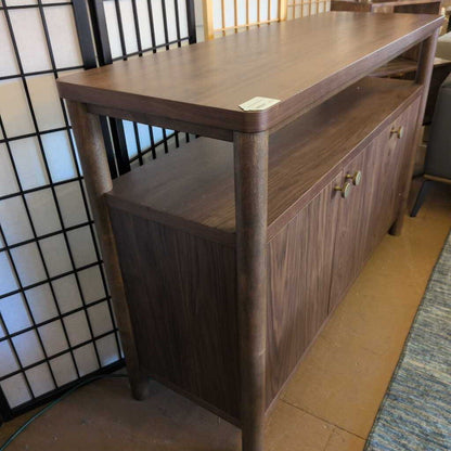 Wooden sideboard with shelves against a wall with a grid pattern