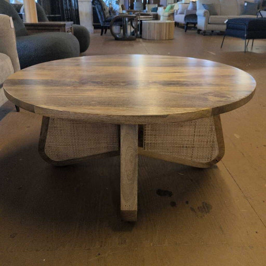 Wooden round table with wicker base in a furniture store setting