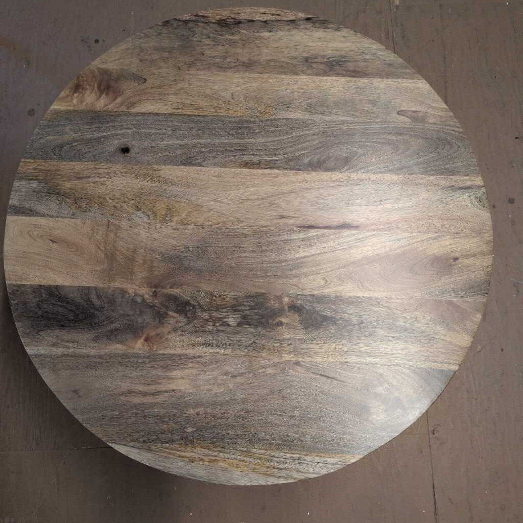 Round wooden cutting board with a natural grain pattern on a plain background