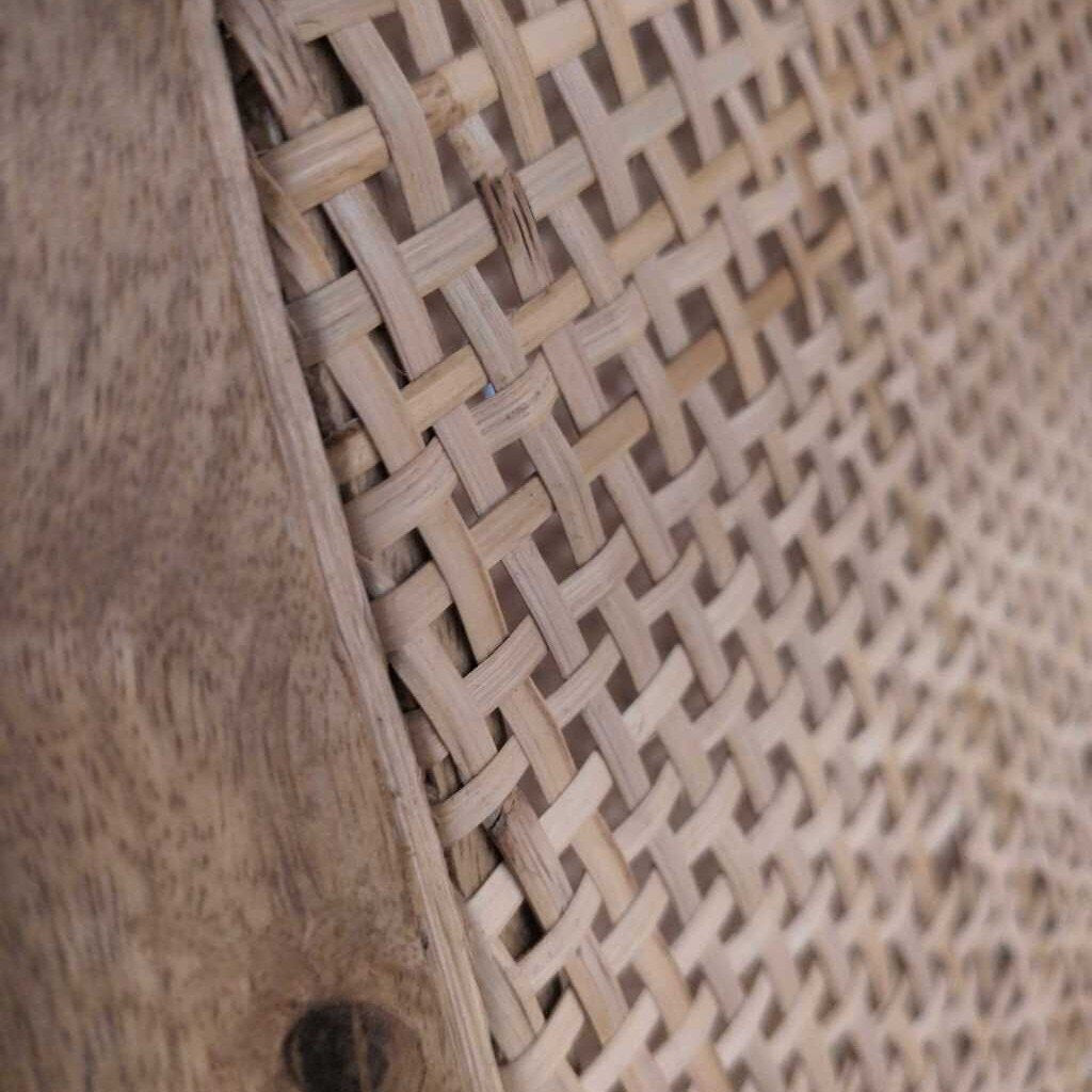 Close-up of a woven rattan surface with a natural wood finish.