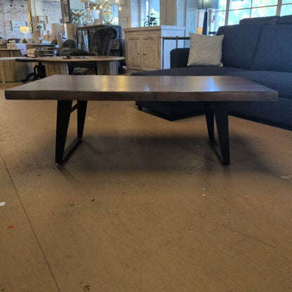 Long wooden table in a room with a couch and chairs.
