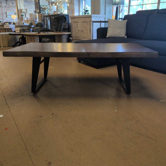 Long wooden table in a room with a couch and chairs.