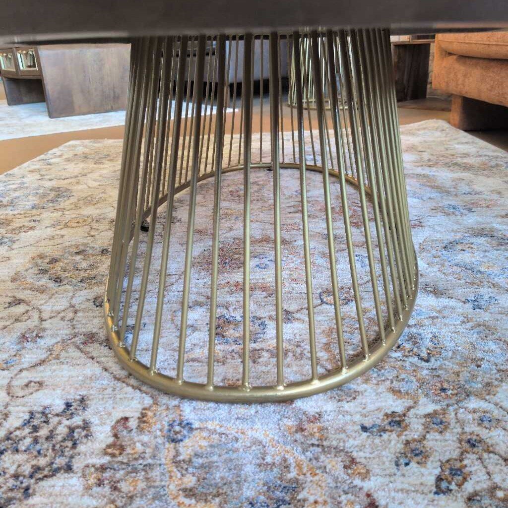 Gold metal stool base on a patterned rug