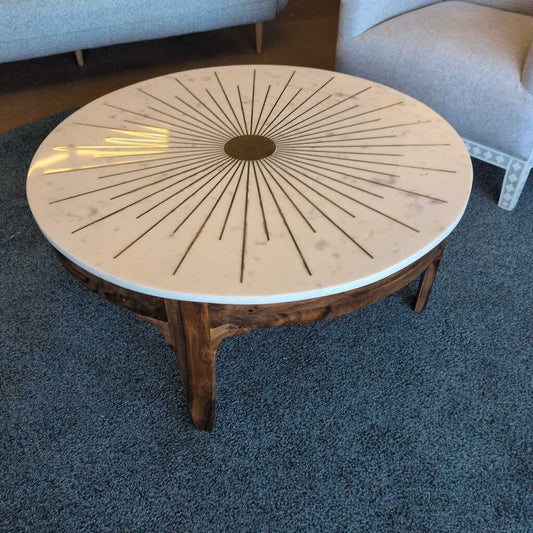 Round wooden coffee table with a decorative top in a living room setting