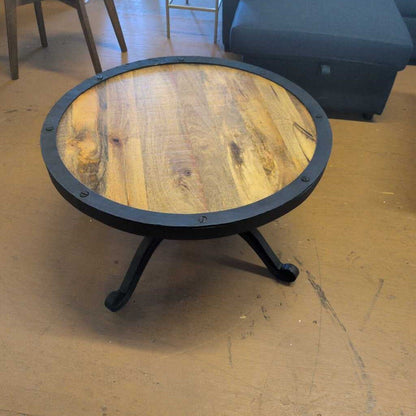 Round wooden table with metal legs on a wooden floor